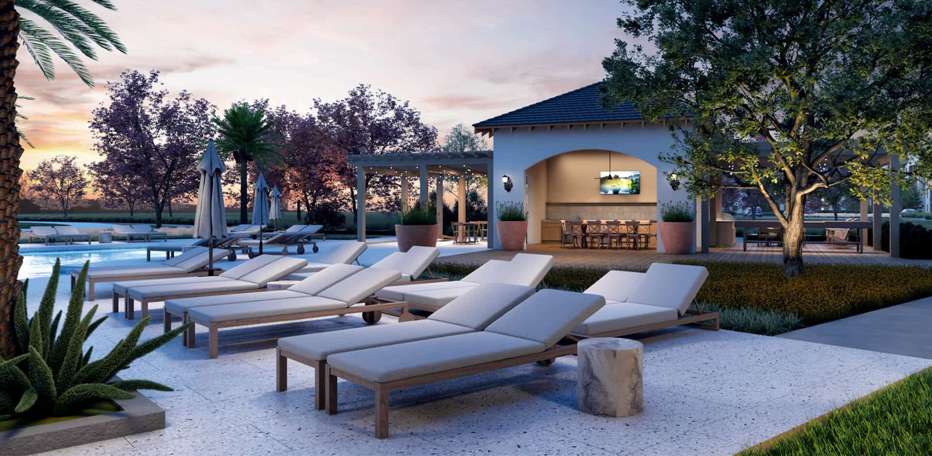 lounge chairs next to a community outdoor dining space and pool at Soluna Apartments